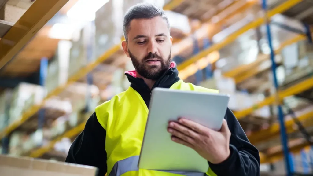 Happy warehouse worker on iPad