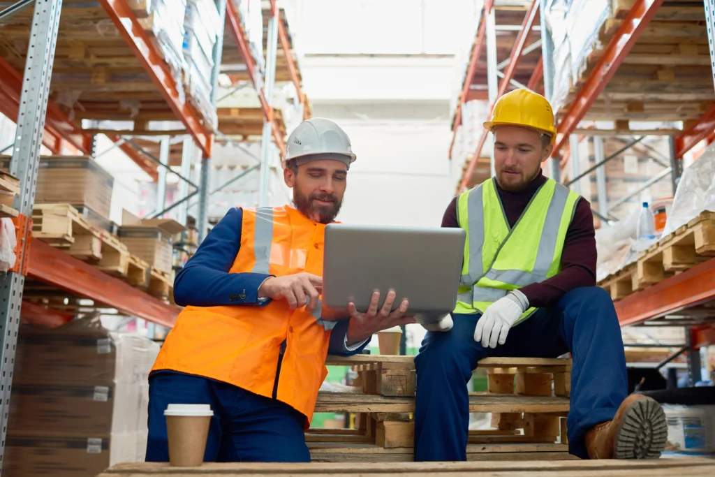 Two workers using Clarus wms on laptop