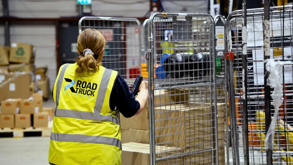 Road truck services female employee pushing crate in warehouse | clarus wms Road truck services female employee pushing crate in warehouse